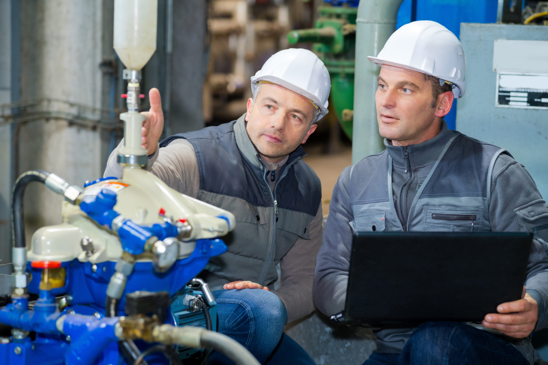 two workers with laptop in factory